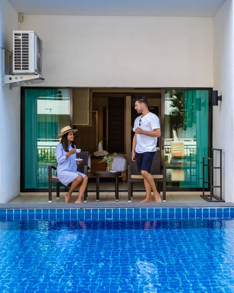 Pareja hombre y mujer bebiendo una taza de café en frente de allí condominio apartamento en Tailandia, mujer asiática y hombre europeo en fron en el balcón del apartamento —  Fotos de Stock