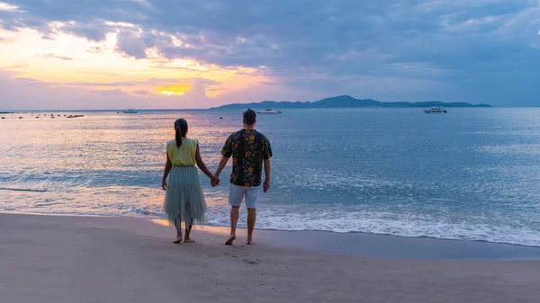 Puesta de sol en la acogedora playa de Pattaya Tailandia, pareja de hombres y mujeres caminando por la playa al atardecer en Pattaya Tailandia — Foto de Stock