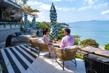 Bir çift, Pattaya Tayland Okyanusu 'na bakan bir restoranda öğle yemeği yiyor. Kadın ve erkek, Pattaya' da okyanus kenarında bir restoranda yemek yiyor.