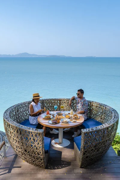 Pareja almorzando en un restaurante con vistas al océano de Pattaya Tailandia, hombre y mujer cenando en un restaurante junto al océano en Pattaya —  Fotos de Stock