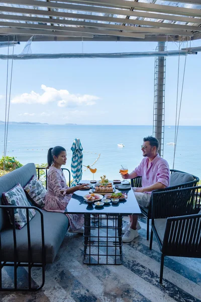 Coppia che pranza in un ristorante affacciato sull'oceano di Pattaya Thailandia, uomo e donna che cenano in un ristorante sull'oceano a Pattaya — Foto Stock