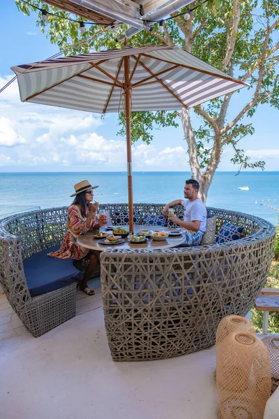 Bir çift, Pattaya Tayland Okyanusu 'na bakan bir restoranda öğle yemeği yiyor. Kadın ve erkek, Pattaya' da okyanus kenarında bir restoranda yemek yiyor. — Stok fotoğraf