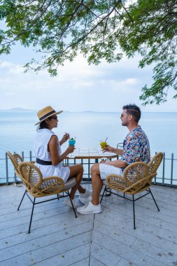 Bir çift, Pattaya Tayland Okyanusu 'na bakan bir restoranda öğle yemeği yiyor. Kadın ve erkek, Pattaya' da okyanus kenarında bir restoranda yemek yiyor.