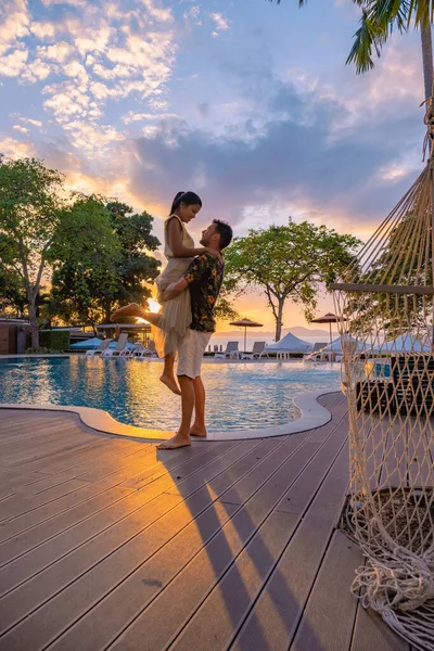 Coucher de soleil sur Cosy Beach Pattaya Thaïlande, couple homme et femme regardant coucher de soleil au bord de la piscine à Pattaya Thaïlande — Photo