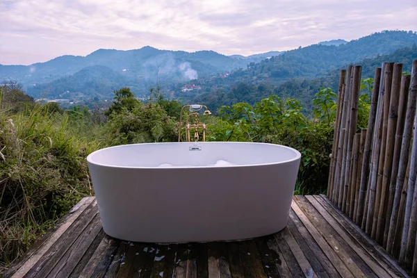 在泰国清迈的山上，黄昏时分，沐浴在浴盆里，在户外的木柴里，在荒原上，沐浴在炽热的浴缸里 — 图库照片