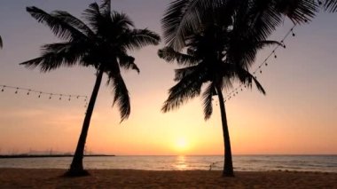 Najomtien plajı Pattaya Tayland, Pattaya Tayland 'da gün batımında palmiye ağaçlarıyla kaplı tropik bir plajda gün batımı.