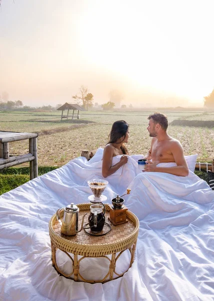 Zonsopgang boven rijstvelden in Nan Thailand, man en vrouw in het buitenbed wakker met koffie in de ochtend in Thailand Nan — Stockfoto