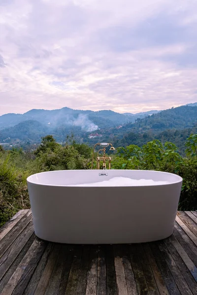 Baignoire pendant le coucher du soleil dans les montagnes de Chiang Mai Thaïlande, élaxage dans le feu de bois extérieur bain à remous dans la nature sauvage — Photo