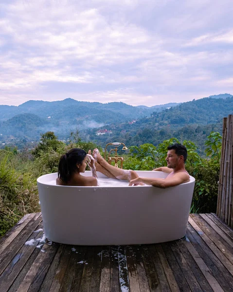 Gün batımında, Chiang Mai Tayland 'ın dağlarında banyo küveti, vahşi doğada, ağaçların arasında jakuzide esneme hareketi. — Stok fotoğraf
