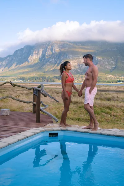 Ζευγάρι άνδρας και γυναίκα στην πισίνα του εκεί καταθέσει για διακοπές στη Νότια Αφρική με θέα τα βουνά κοντά Hermanus — Φωτογραφία Αρχείου