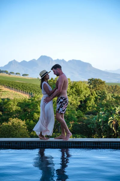 Pár muž a žena v bazénu s výhledem na vinice a hory Stellenbosch Jižní Africe — Stock fotografie
