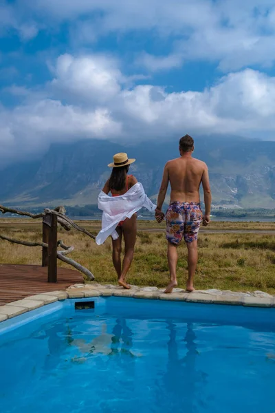 Coppia uomo e donna in piscina di lì lodge in vacanza in Sud Africa con vista sulle montagne vicino Hermanus — Foto Stock