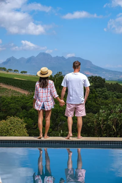 南非斯泰伦博希葡萄园和山上的游泳池里，男人和女人在一起凝视着 — 图库照片