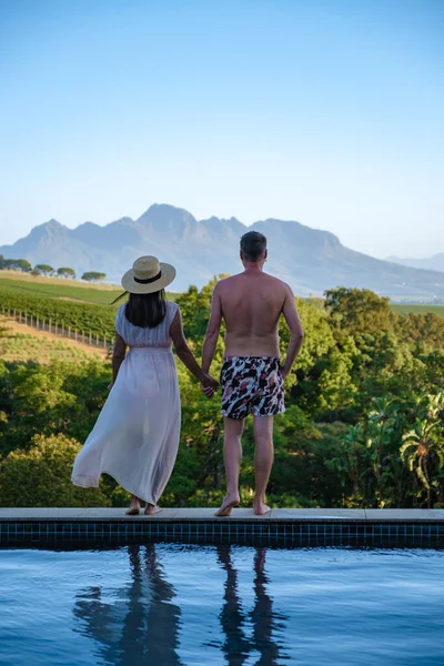 Coppia uomo e donna in piscina con vista sui vigneti e sulle montagne di Stellenbosch Sud Africa — Foto Stock
