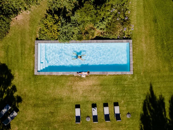 Drohnenblick auf den Swimmingpool oben mit Mann und Frau beim Schwimmen in Stellenbosch in der Nähe von Kapstadt, Südafrika — Stockfoto