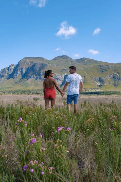 Man en vrouw in grasland tijdens vakantie in Zuid-Afrika, bergen en grasland in de buurt van Hermanus op de tuinroute West-Kaap Zuid-Afrika Walviskust — Stockfoto