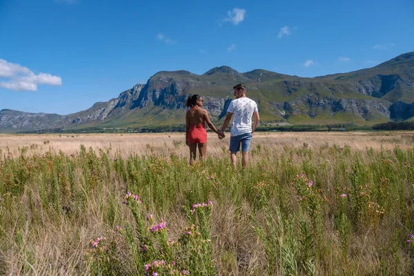 Man en vrouw in grasland tijdens vakantie in Zuid-Afrika, bergen en grasland in de buurt van Hermanus op de tuinroute West-Kaap Zuid-Afrika Walviskust — Stockfoto