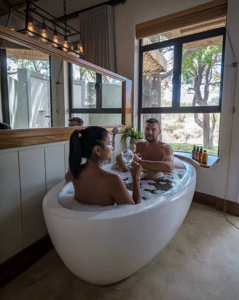 Pareja de hombres y mujeres en la bañera en un safari de lujo, Sudáfrica, safari de lujo lodge en el monte — Foto de Stock