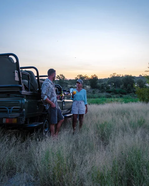 Sudáfrica, coche safari de lujo durante la unidad de juego, pareja de hombres y mujeres en safari en Sudáfrica —  Fotos de Stock