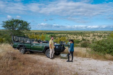 Güney Afrika, oyun sürüşü sırasında lüks safari arabası, Güney Afrika 'da safari yapan birkaç erkek ve kadın.