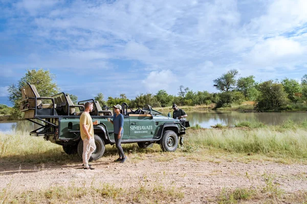 Republika Południowej Afryki, luksusowy samochód safari podczas jazdy gry, para mężczyzn i kobiet na safari w Republice Południowej Afryki — Zdjęcie stockowe