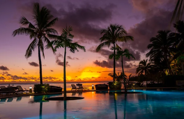 Pôr do sol piscina tropical com palmeiras, pôr do sol junto à piscina com palmeiras durante as férias na Maurícia — Fotografia de Stock