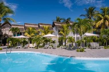Plaj sandalyeli ve şemsiyeli tropik havuz, Mauritius 'ta yüzme havuzu.