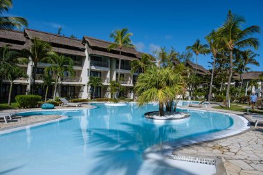 Plaj sandalyeli ve şemsiyeli tropik havuz, Mauritius 'ta yüzme havuzu.