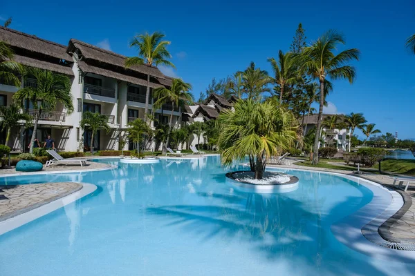 Тропический бассейн с шезлонгами и зонтиками, бассейн на Маврикии — стоковое фото