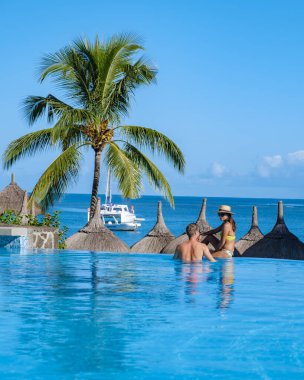Sıcak güneşli bir gün cennet hedef tatil sırasında güzel tropik sahil otel resort Yüzme Havuzu, güneş-şezlong ve palmiye ağaçları