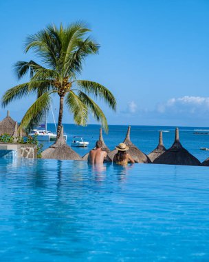 Sıcak güneşli bir gün cennet hedef tatil sırasında güzel tropik sahil otel resort Yüzme Havuzu, güneş-şezlong ve palmiye ağaçları