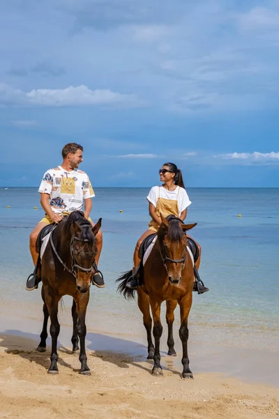 Paardrijden op het strand, man en vrouw te paard op het strand tijdens een luxe vakantie op Mauritius — Stockfoto