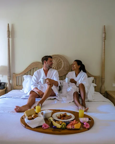 Koppel man en vrouw van middelbare leeftijd ontbijten in bed slaapkamer van een appartement luxe hotel appartement in Mauritius — Stockfoto