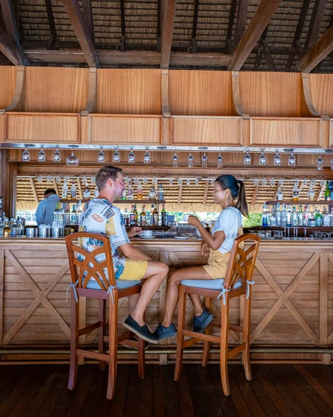 Couple man and woman having a drink in the bar on a tropical Island during vacation — Photo