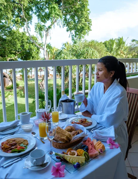 Woman mid age having breakfast on their balcony of an appartment luxury hotel condo in Mauritius — 스톡 사진