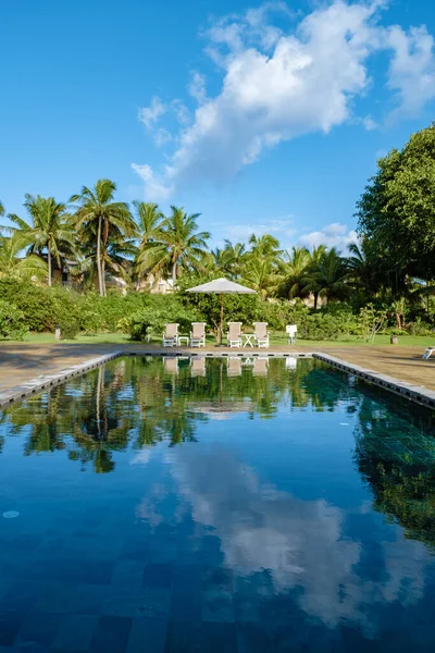 Medence strandszékekkel és ebédlőasztallal luxus üdülőhelyen, trópusi medence — Stock Fotó