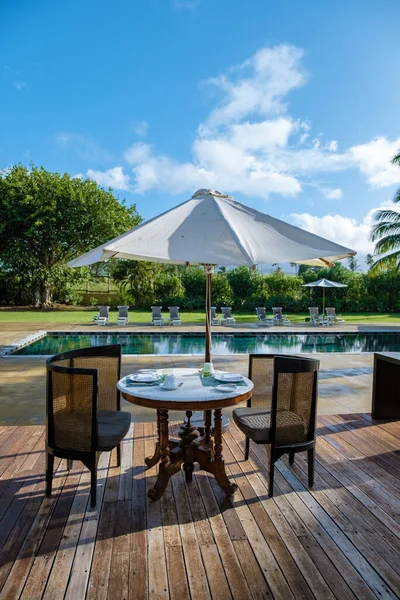 Piscina com cadeiras de praia e mesa de almoço em um resort de luxo, piscina tropical — Fotografia de Stock