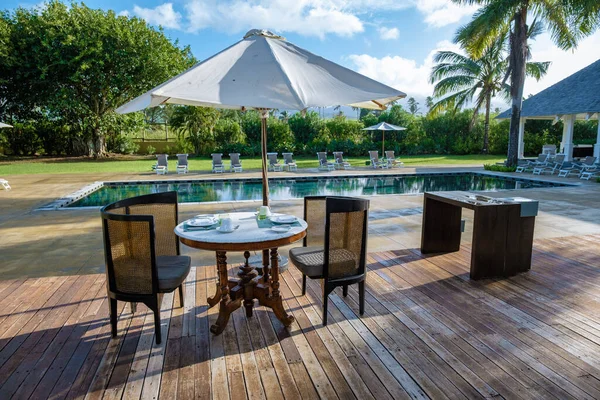 Swimming pool with beach chairs and lunch table at a luxury resort, tropical pool — Foto Stock