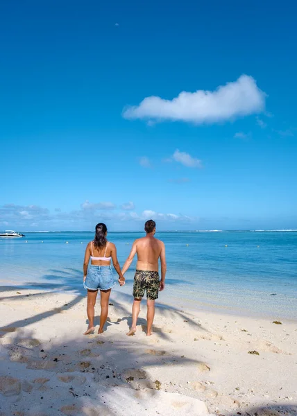Ζευγάρι άνδρες και γυναίκα στην τροπική παραλία, τροπική παραλία με λευκή άμμο και φοίνικες Le Morne Μαυρίκιος, λευκή αμμώδη παραλία με μπλε ωκεανό και φοίνικες Μαυρίκιος — Φωτογραφία Αρχείου
