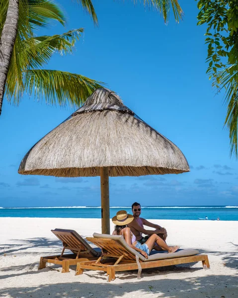 ヤシの木と白い砂の青い海と傘付きのビーチベッド、熱帯のビーチでヤシの木の下のサンチェアとパラソル、ル・モーンビーチモーリシャス — ストック写真