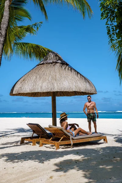 ヤシの木と白い砂の青い海と傘付きのビーチベッド、熱帯のビーチでヤシの木の下のサンチェアとパラソル、ル・モーンビーチモーリシャス — ストック写真