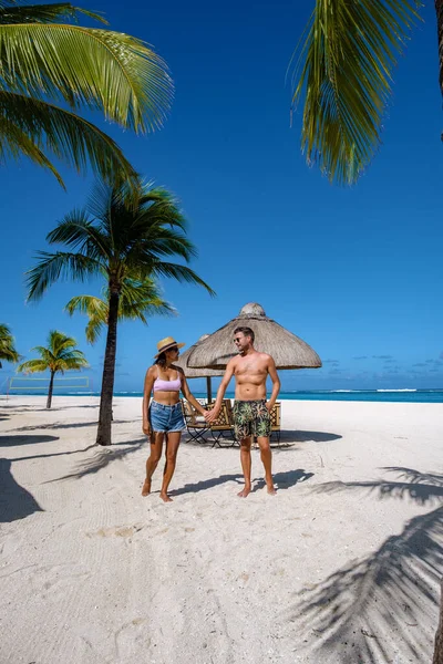 Spiaggia tropicale con palme e sabbia bianca oceano blu e lettini con ombrellone, sedie a sdraio e ombrellone sotto una palma in una spiaggia tropicale, Le Morne spiaggia Mauritius — Foto Stock