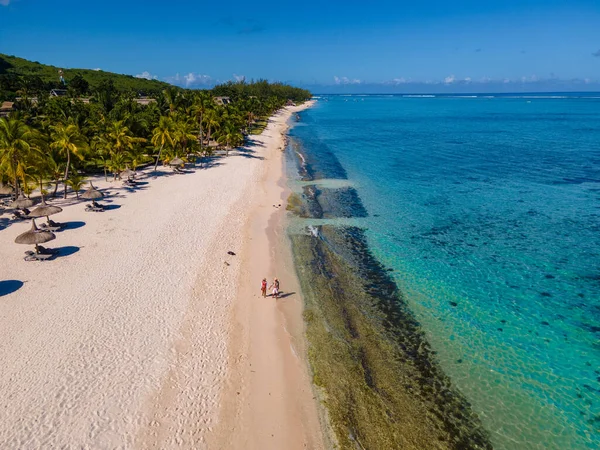 Le Morne beach Mauritius,Tropical beach with palm trees and white sand blue ocean couple men and woman walking at the beach during vacation — 스톡 사진