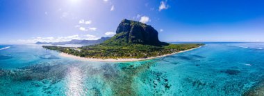 Le Morne beach Mauritius,Tropical beach with palm trees and white sand blue ocean and beach beds with umbrella,Sun chairs and parasol under a palm tree at a tropical beac, Le Morne beach Mauritius