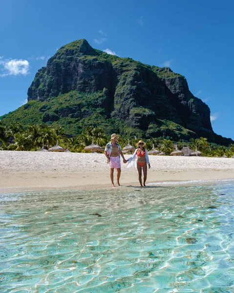 Le Morne beach Mauritius,Tropical beach with palm trees and white sand blue ocean couple men and woman walking at the beach during vacation — Stockfoto