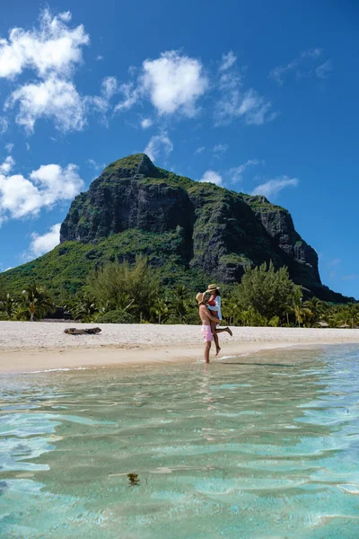 Le Morne beach Mauritius,Tropical beach with palm trees and white sand blue ocean couple men and woman walking at the beach during vacation — Stockfoto