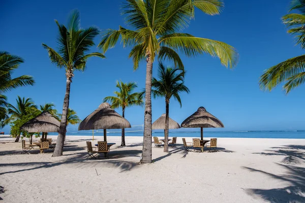 Le Morne playa Mauricio, Playa tropical con palmeras y arena blanca azul océano y camas de playa con sombrilla, tumbonas y sombrilla bajo una palmera en una playa tropical, Le Morne playa Mauricio — Foto de Stock