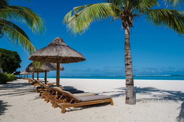 Le Morne playa Mauricio, Playa tropical con palmeras y arena blanca azul océano y camas de playa con sombrilla, tumbonas y sombrilla bajo una palmera en una playa tropical, Le Morne playa Mauricio — Foto de Stock