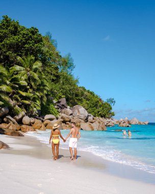 Praslin Seyşeller tropikal adasında plajlar ve palmiye ağaçları var. Orta yaşlı birkaç erkek ve kadın tatilde Seyşeller 'de Anse Lazio Praslin Seyşeller' in tropik plajını ziyaret ediyor.