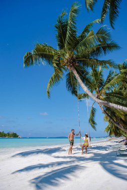 Praslin Seyşeller tropikal adasında, bilge plajlar ve palmiye ağaçları, hamakta sallanan bir çift erkek ve kadın Anse Volber Seyşeller 'deki bir palmiye ağacının altında.